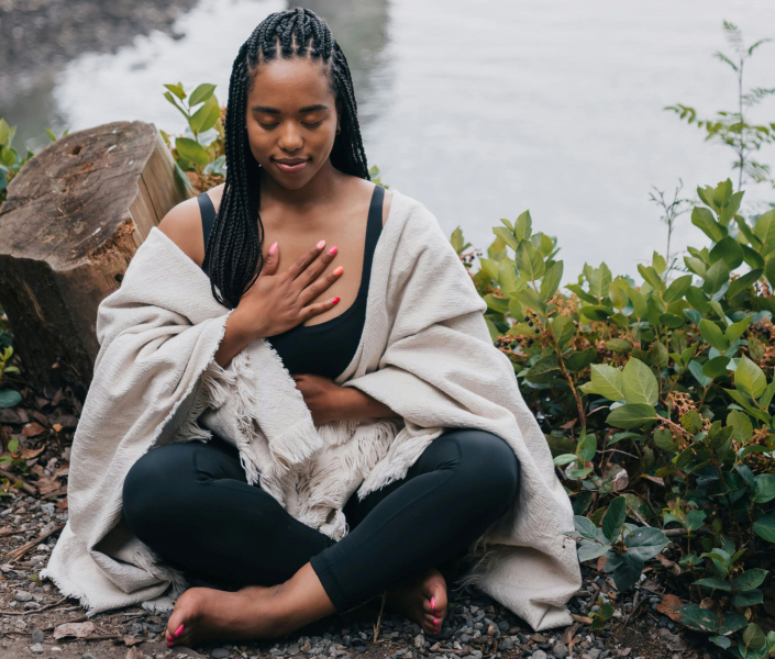 image of woman sitting with hand on chest